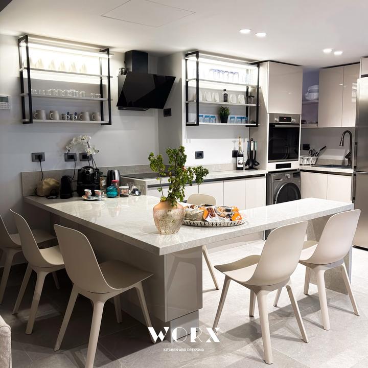 Kitchen with black-framed open shelving and a stone peninsula table
