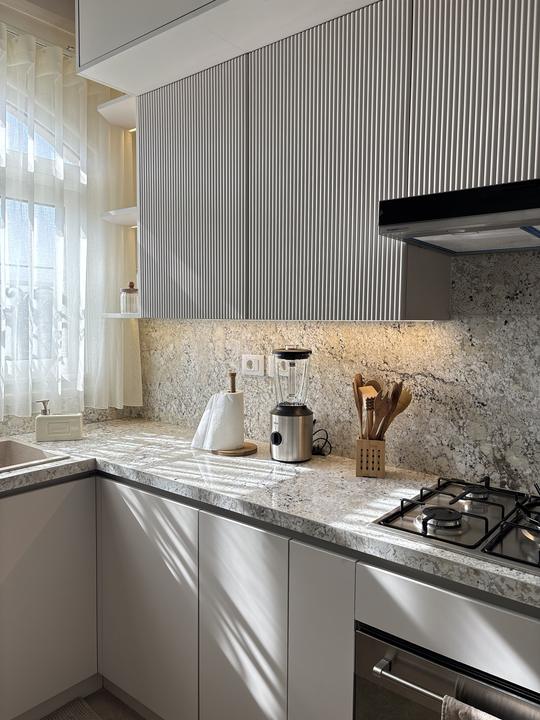 Fluted cabinet fronts over a granite backsplash