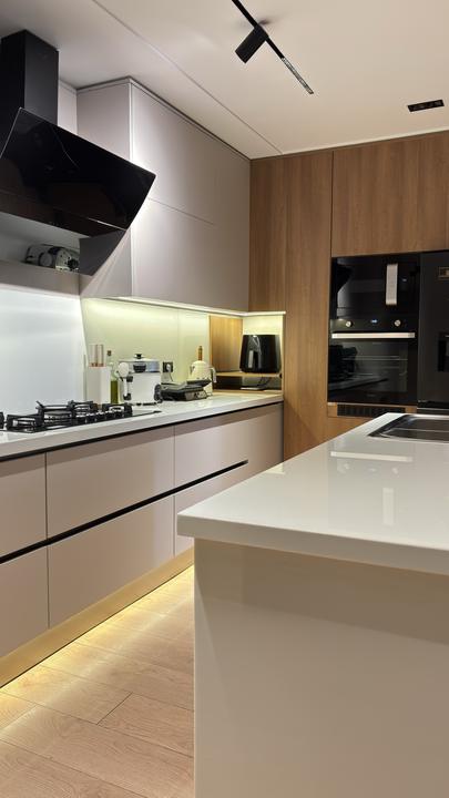 Light grey kitchen with oak tall units and built-in ovens