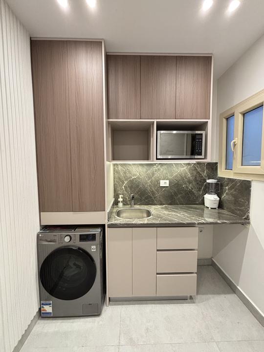 Laundry room with washer housing, sink and marble worktop
