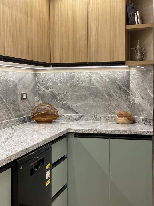 Sage green base cabinets, oak uppers and grey marble backsplash