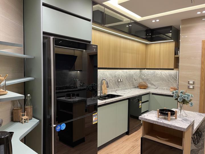 Sage green and oak kitchen with smoked-glass upper cabinets