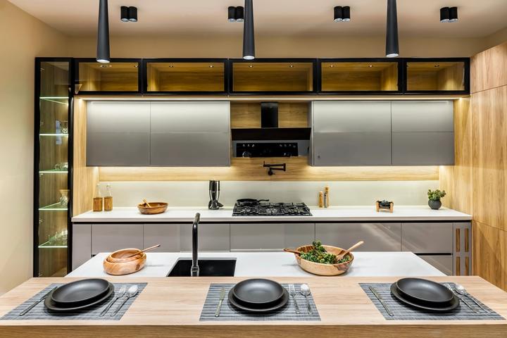 Grey gloss kitchen with lit glass upper cabinets and a set dining bar