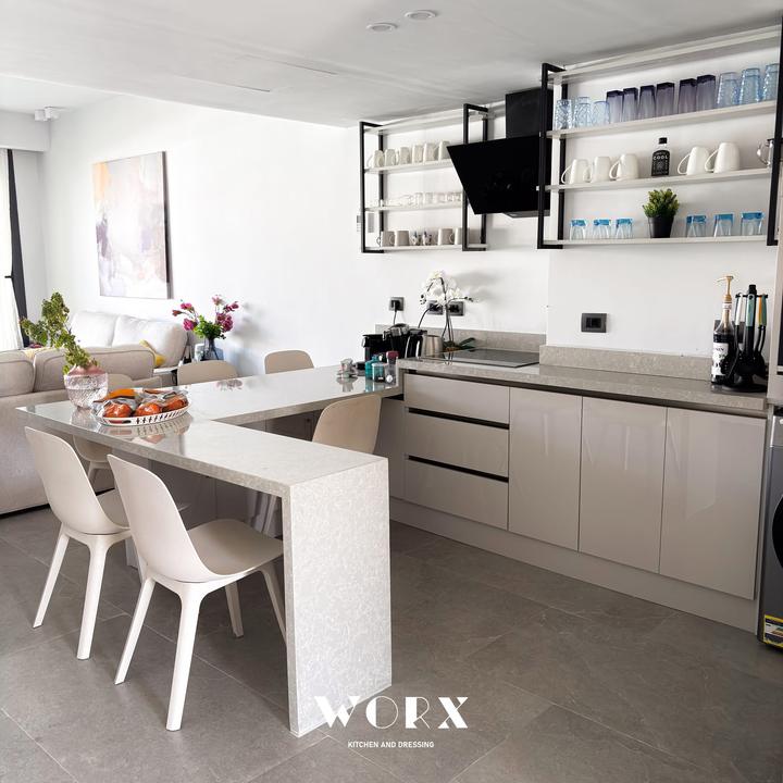 Stone waterfall dining peninsula with open shelving in daylight