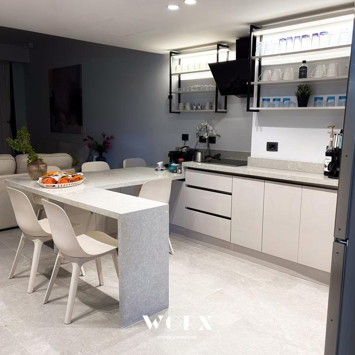 Stone waterfall peninsula and gloss cabinets in the evening