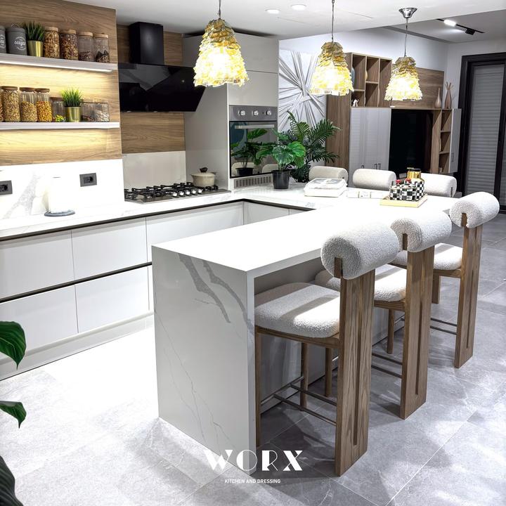 White kitchen with marble waterfall peninsula and bouclé bar stools