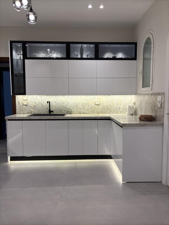 White gloss L-shaped kitchen with black-framed glass display cabinets