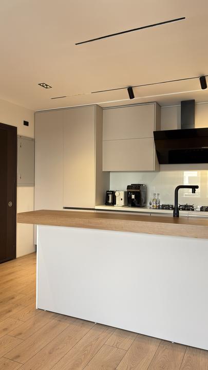 Handleless white kitchen with solid wood breakfast bar
