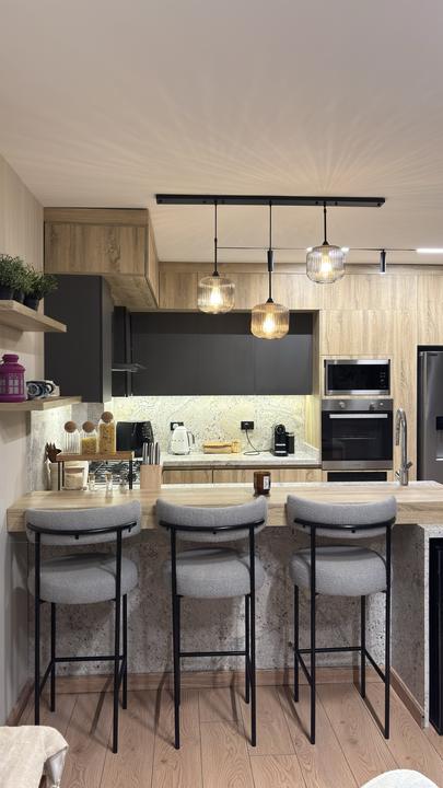 Oak and matte black kitchen with breakfast bar and pendant lights