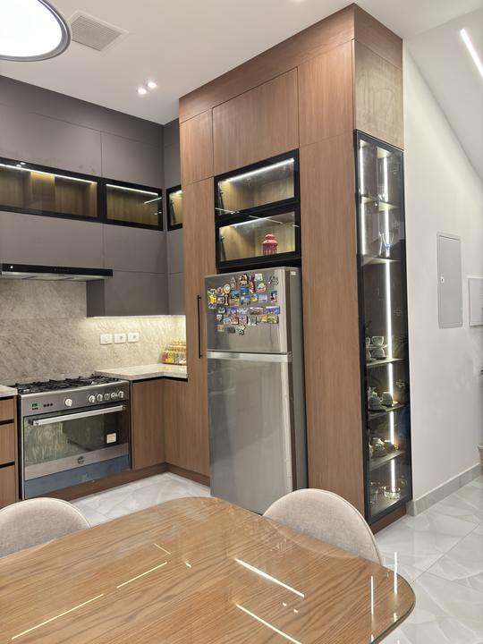 Tall walnut units with fridge housing and lit glass display column
